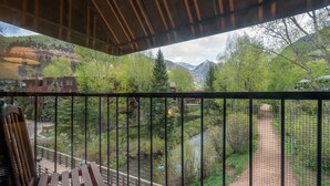 A balcony with a view of a river, trees, and mountains. - Manitou Lodge 7 Hotel Room by Alpine Lodging Telluride (Telluride)