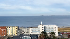 Un hôtel avec vue sur la mer, composé de plusieurs bâtiments dotés de balcons et disposant d’un parking.