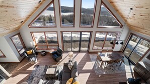 A spacious loft with large windows offering views of a snowy landscape. - Lax Lake View Retreat (Silver Bay)