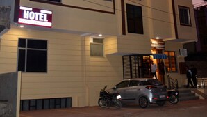A multi-story hotel with a sign indicating it is a hotel. There are windows on each floor, and a car is parked in front. - Hotel Ranthambhore Uday (Sawai Madhopur)