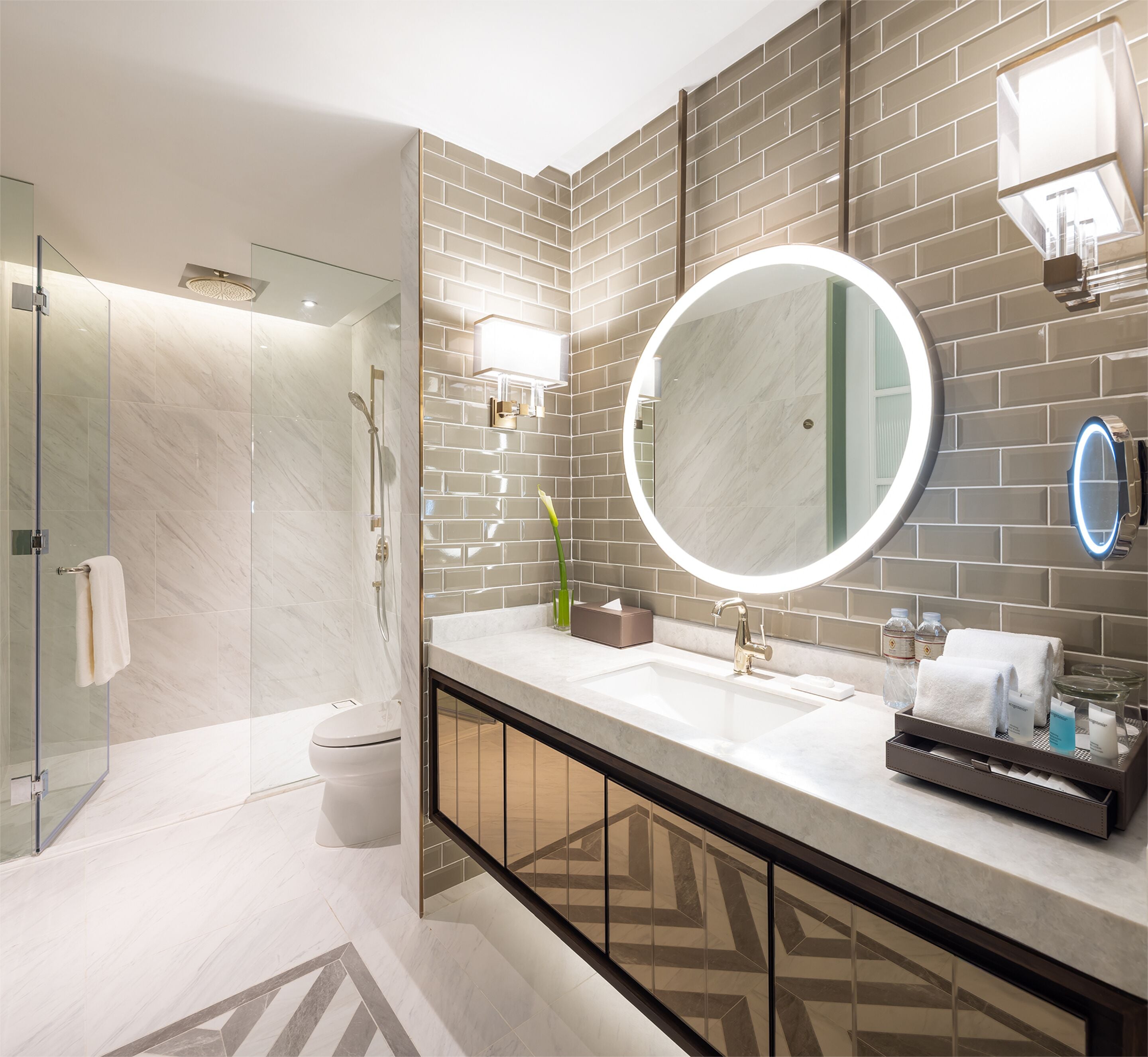 A modern bathroom with a large mirror, a sink, and a shower area.