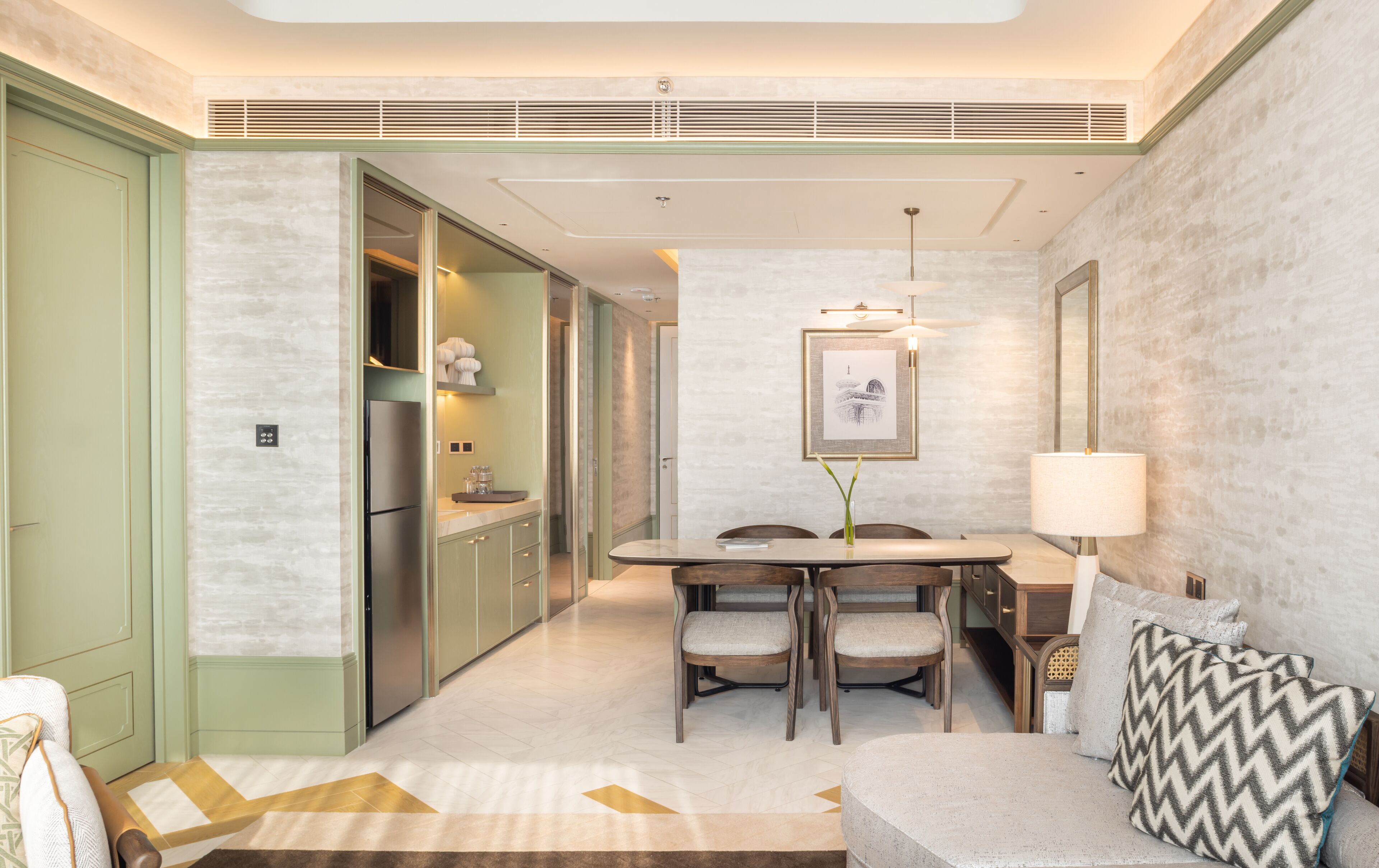 Una habitación de hotel moderna con comedor, sofá y un espejo grande.