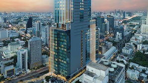 Un edificio de gran altura con fachada de vidrio moderna y un letrero llamativo en la parte superior.
