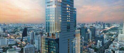 Un edificio de gran altura con fachada de vidrio moderna y un letrero llamativo en la parte superior.