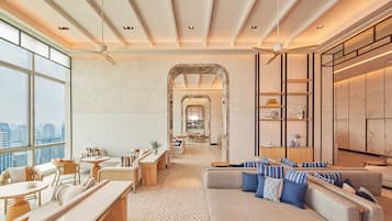 A spacious hotel lobby with a high ceiling, large windows, and a modern interior design.