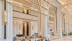 Un vestíbulo espacioso con techo alto, muebles modernos y un candelabro.