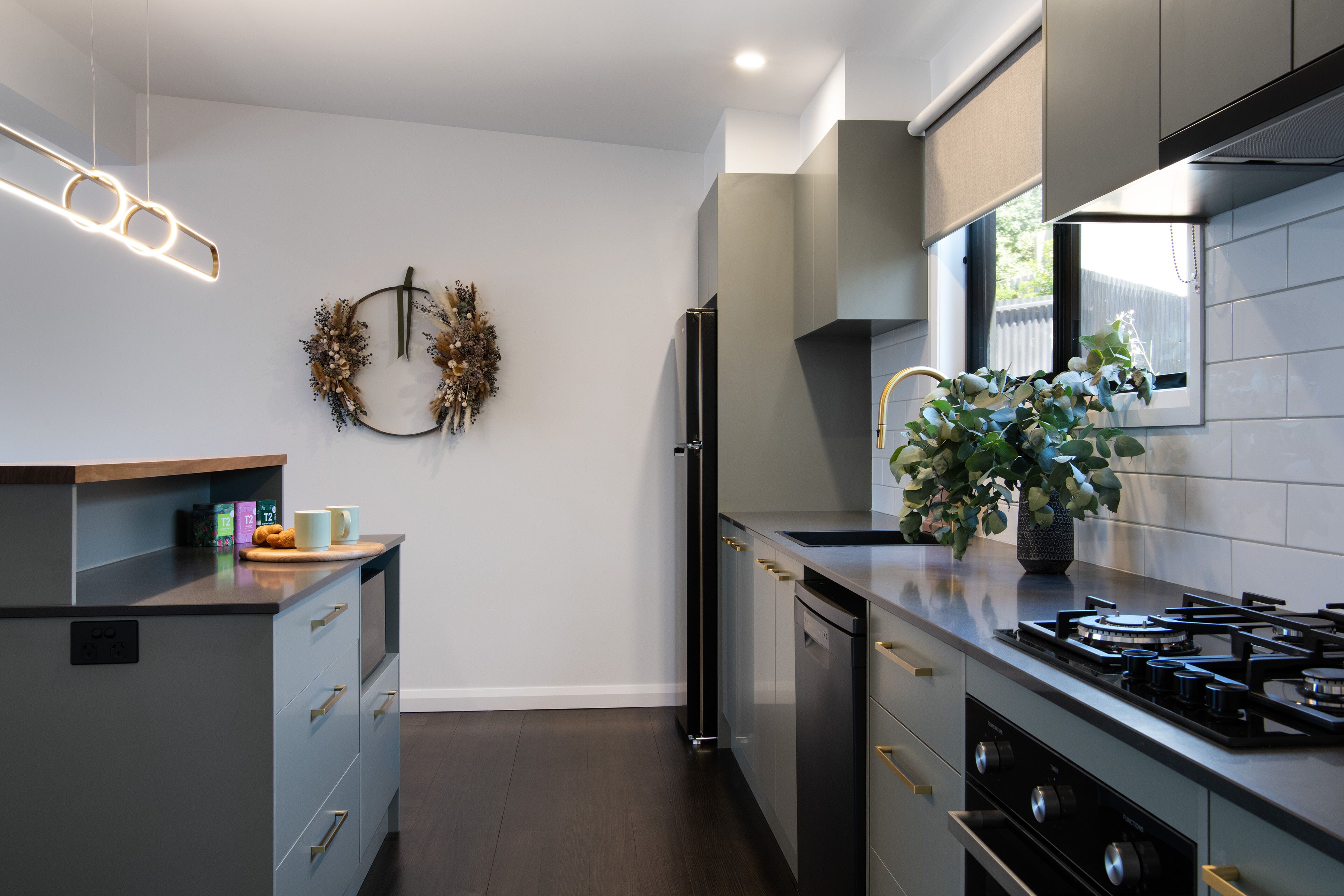 A modern kitchen with a built-in oven, a refrigerator, and a gas stove.
