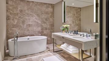 A modern bathroom with a freestanding bathtub, a double sink vanity, and a large mirror.