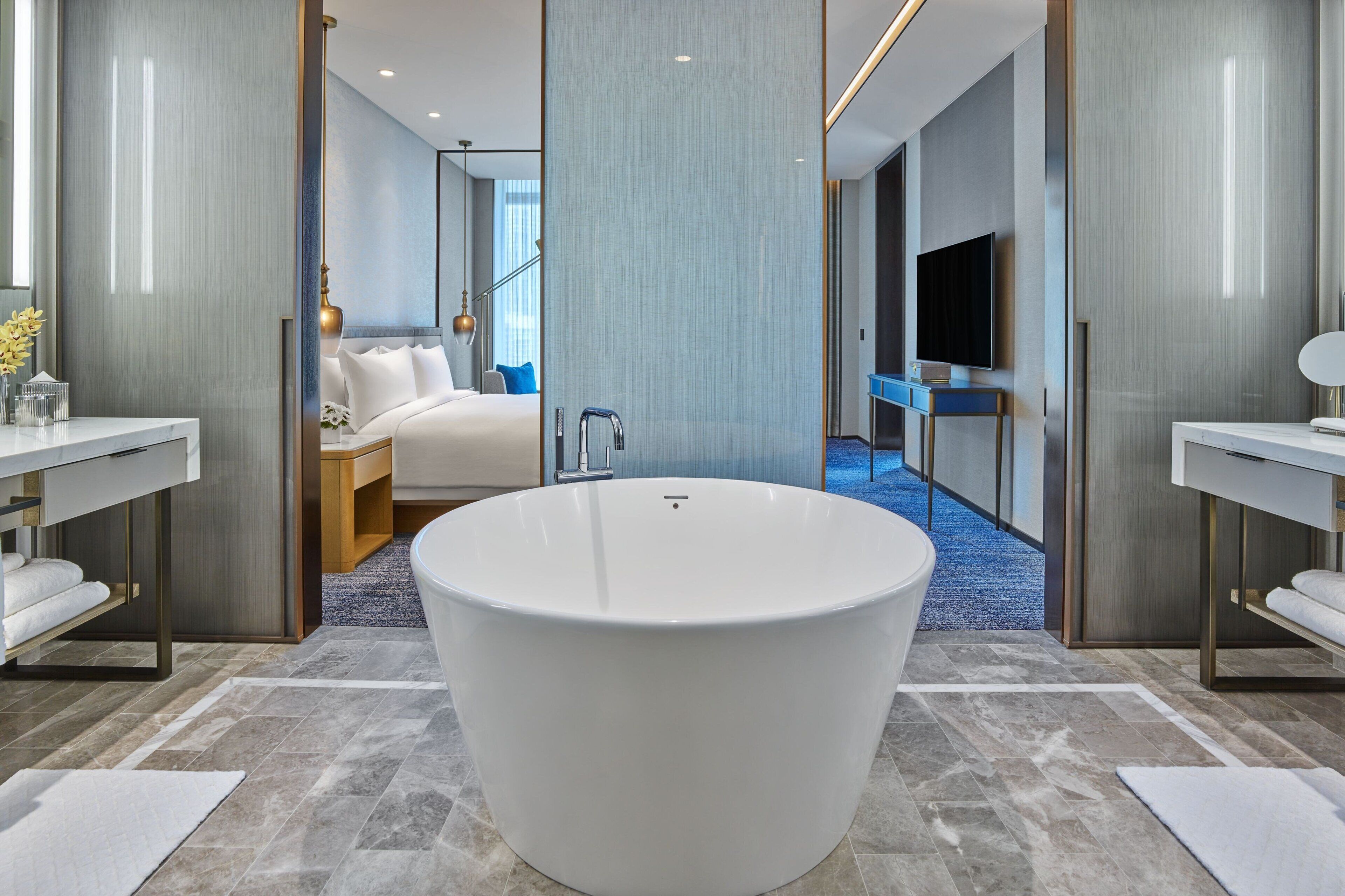 Un bagno moderno con una vasca da bagno indipendente di grandi dimensioni, un lavabo doppio e un grande specchio.