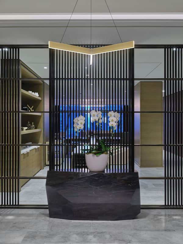 Contemporary space with a central bench, vertical slats, and a wooden panel wall.