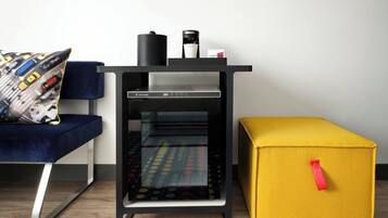 Un espacio habitable moderno con un juego de mobiliario negro y amarillo, que incluye un sofá, una cafetera y un refrigerador SmartFridge.