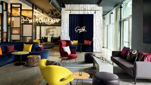 A modern lounge area with sofas, chairs, and a neon sign. - Aloft by Marriott Henderson (Henderson)