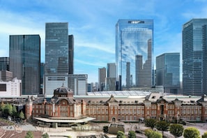 Un paisaje urbano con rascacielos modernos y una estación de tren histórica.