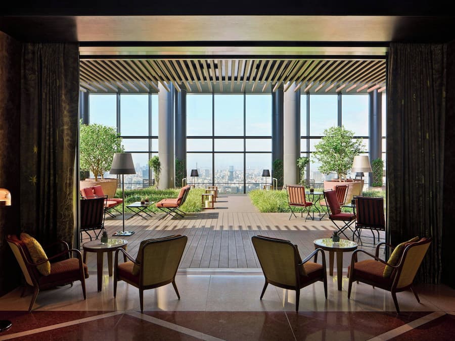A modern indoor patio with large windows, comfortable seating, and a city view.