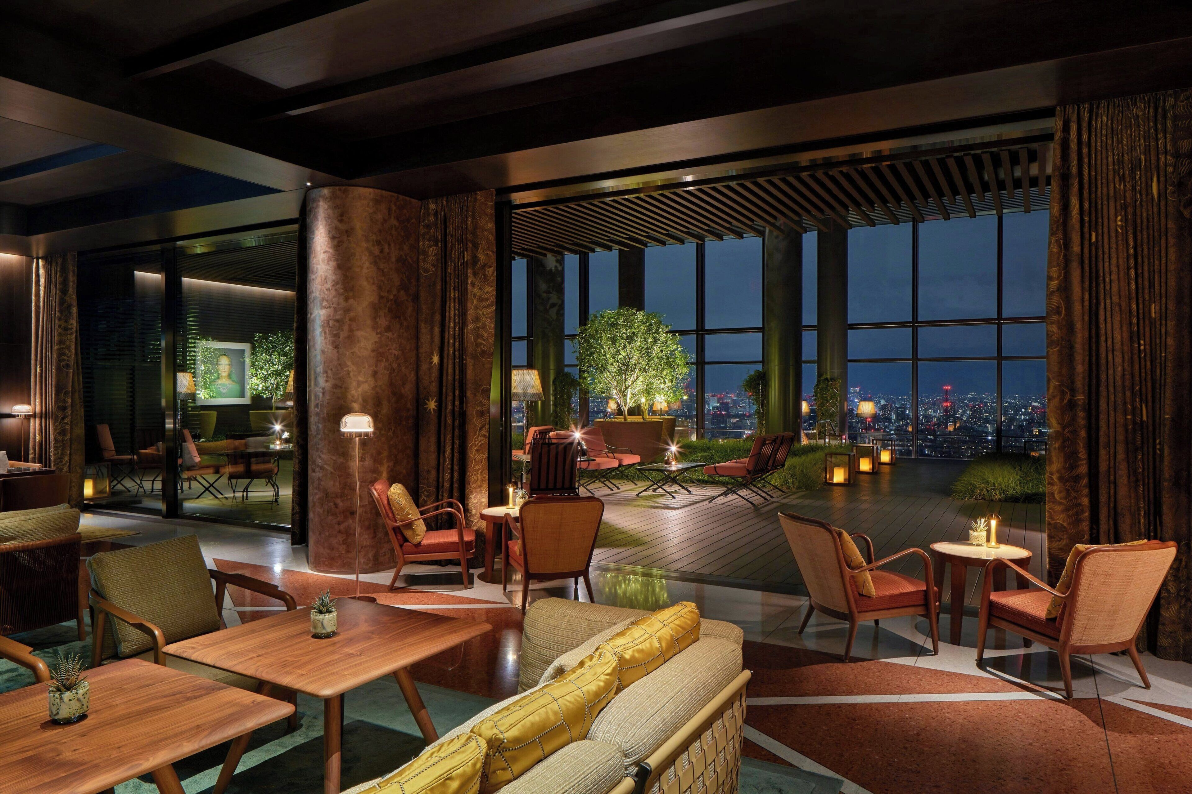 A modern hotel lobby with a large window offering a city view, comfortable seating, and ambient lighting.