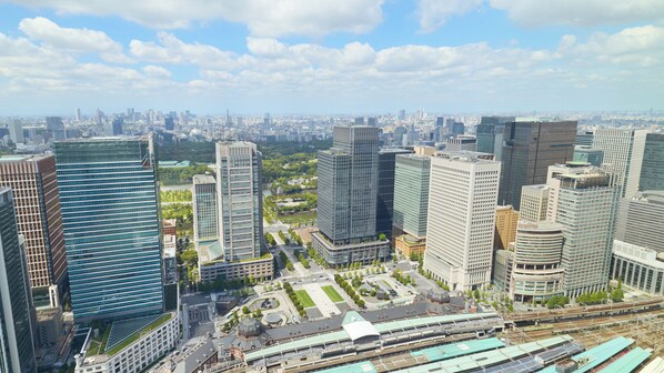 A high-rise urban area with modern skyscrapers, a central plaza, and a train station.