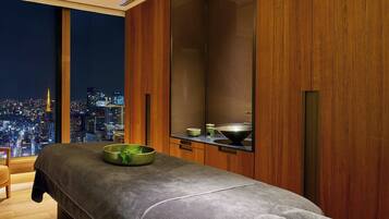 Ein modernes Zimmer mit Blick auf die Stadt, einer Massageliege und Holzschränken.