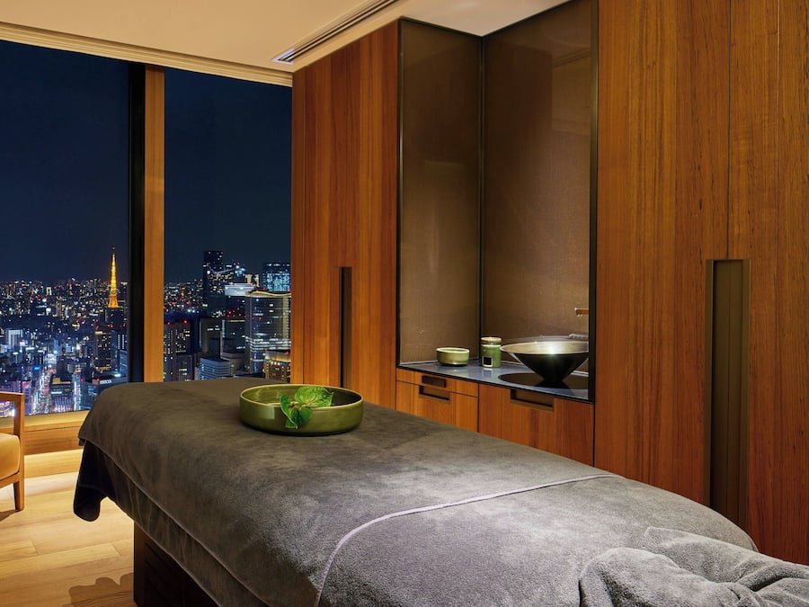 Ein modernes Zimmer mit Blick auf die Stadt, einer Massageliege und Holzschränken.