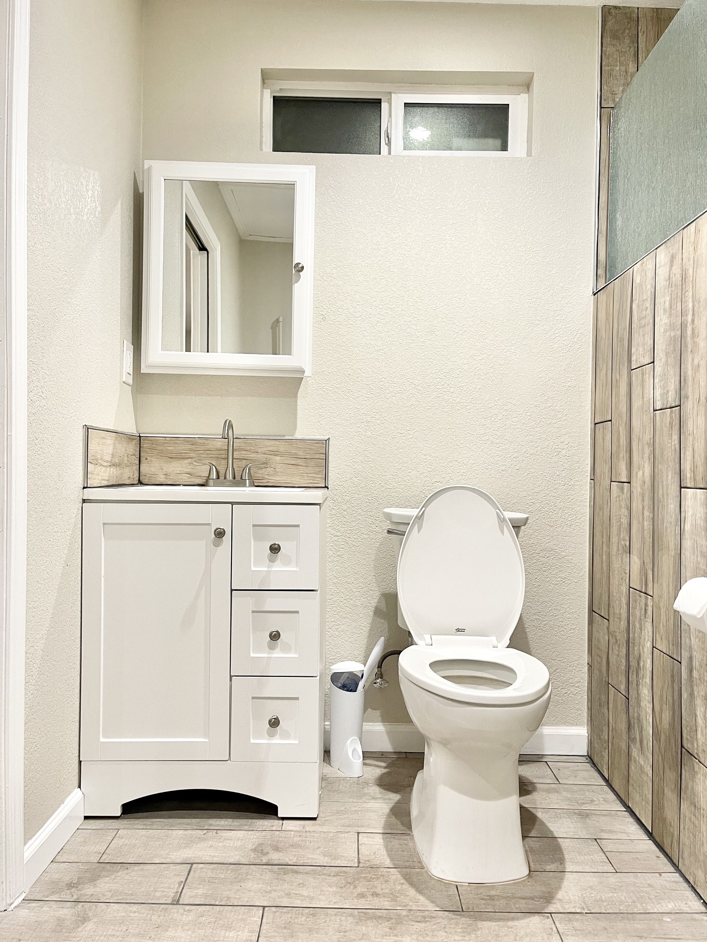 Ein Badezimmer mit Toilette, Waschbecken und Spiegel.