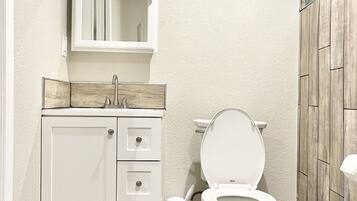 Ein Badezimmer mit Toilette, Waschbecken und Spiegel.
