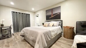 Un dormitorio moderno con una cama grande, un escritorio y una silla.