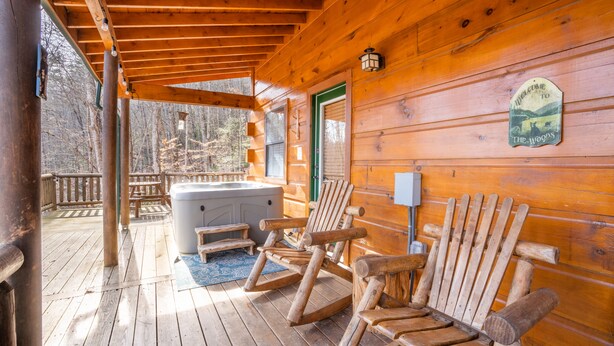A wooden deck with Adirondack chairs and a hot tub. - Bearway to Heaven #2 (Pigeon Forge)