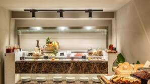 A buffet setup with various food items and condiments.
