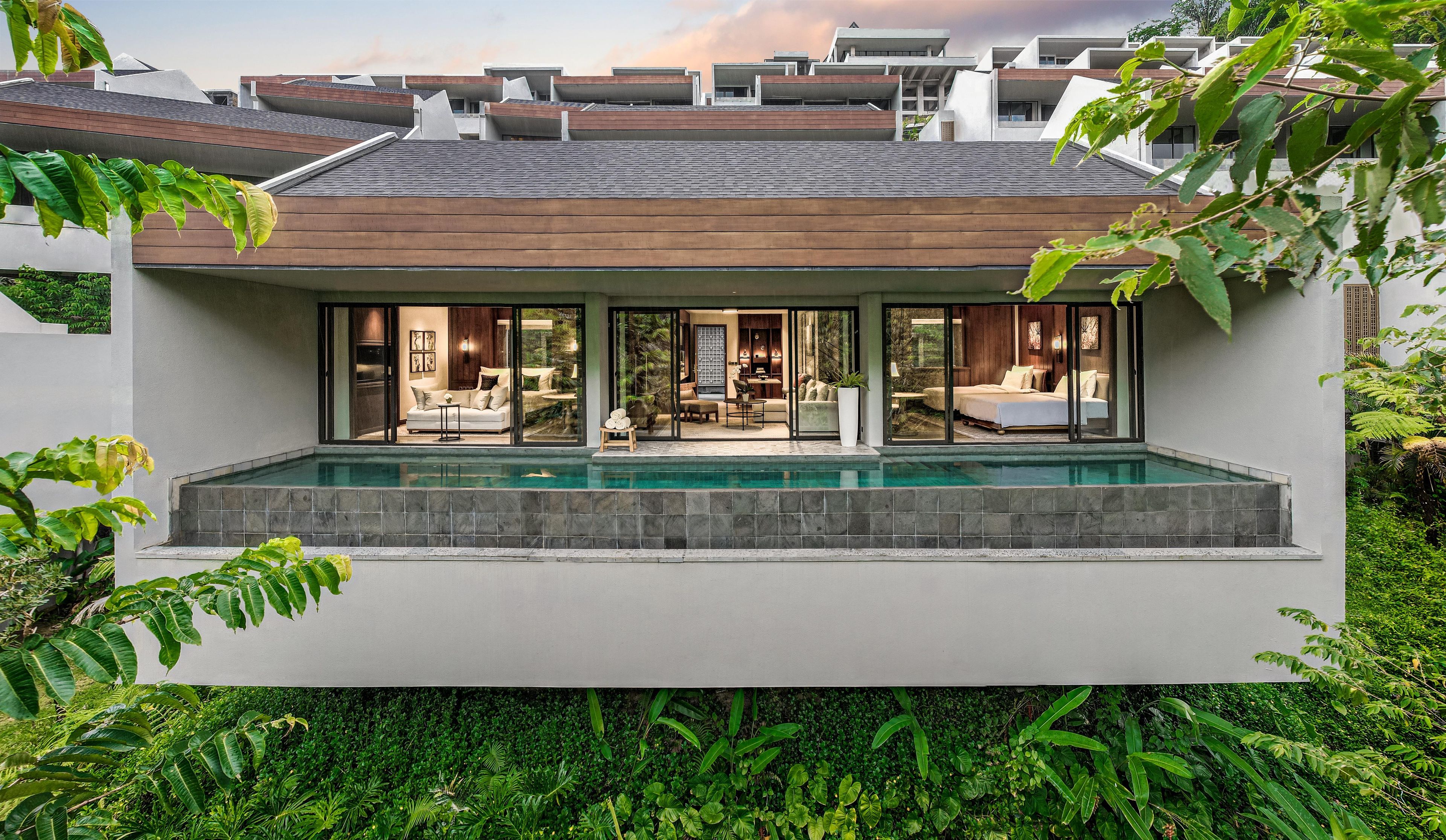A modern house with a swimming pool, large windows, and a garden.