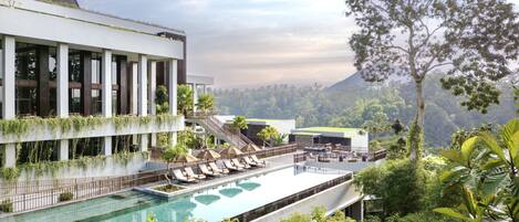 Un hotel moderno con piscina, asientos al aire libre y abundante vegetación.