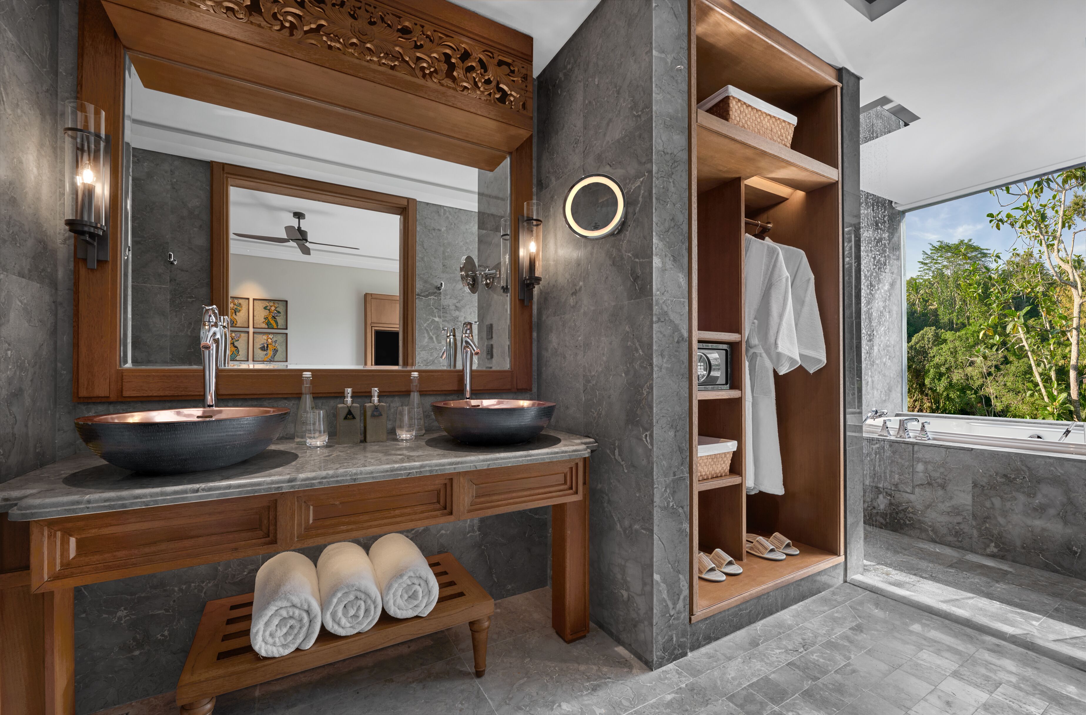 A modern bathroom with two sinks, a large mirror, and a built-in shower area.