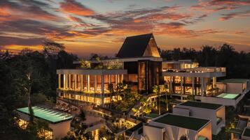 A modern resort with multiple buildings, interconnected walkways, and a pool area.
