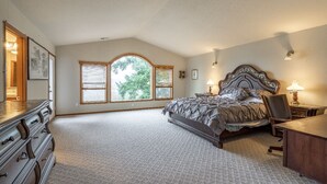 A bedroom with a large bed, a dresser, a desk, and a window with blinds. - Beautiful house near Columbia Gorge (Gresham)