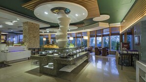 Un moderno vestíbulo de hotel con una isla central de diseño espiral único, rodeada de zonas de estar y grandes ventanales.