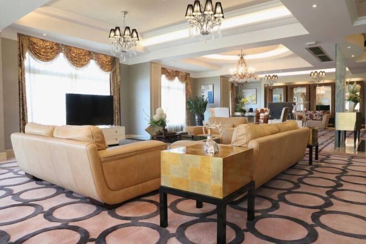 A spacious living room with a sofa, a coffee table, and a TV.