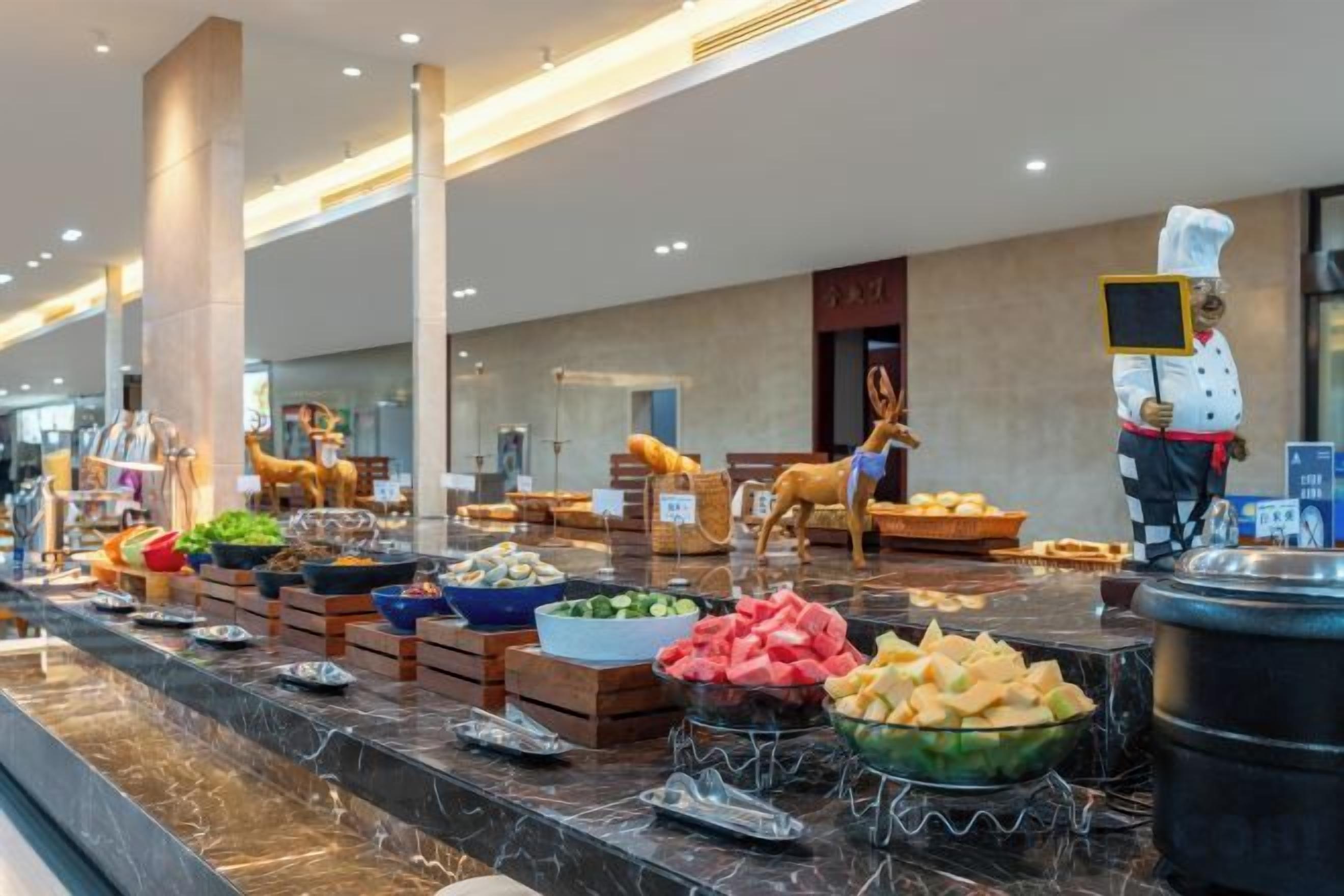 A buffet with various food items and a chef in uniform.