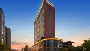 A tall hotel building with a modern design, featuring a prominent signage at the top. - Days Hotel by Wyndham Hunan Zhangjiajie (Zhangjiajie)