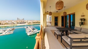 A balcony with a view of a marina and cityscape. - Maison Privee - Exclusive Apt with Seafront Views over Palm Jumeirah (Dubai)