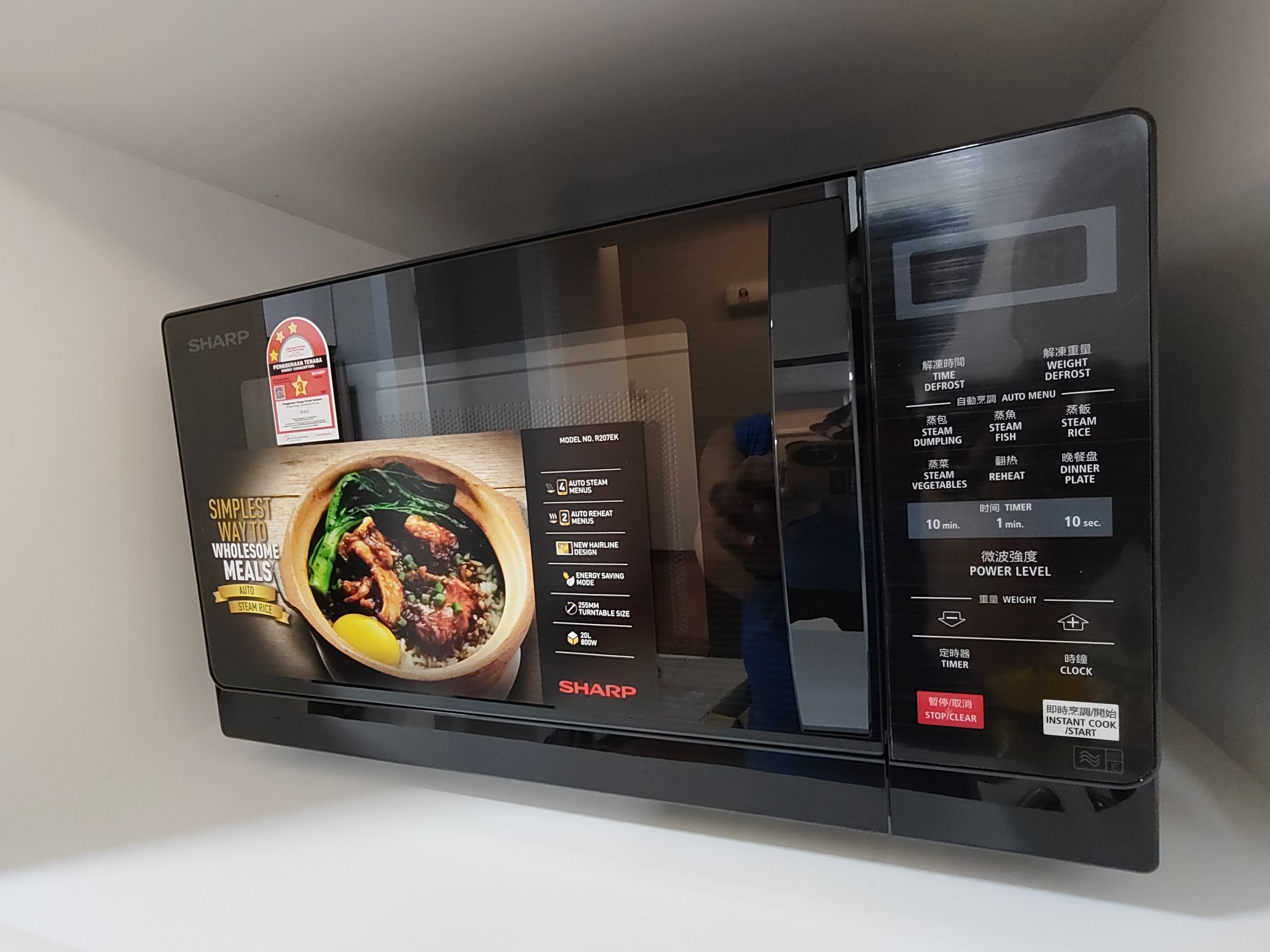 A Sharp microwave with a digital display showing various cooking options and settings.