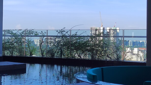 An indoor swimming pool with clear views of the cityscape and buildings in the background. - Executive Azure Next to New World Hotel (Petaling Jaya)