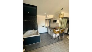 A modern kitchen with a built-in oven, a dining area with a bar stool, and a large window.