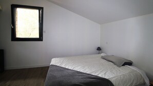 A bedroom with a single bed, a window, and a lamp. - Pretty wooden house 5 minutes from the ocean (Labenne)