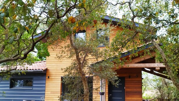 A two-story wooden house with a porch, a small deck, and a window overlooking the yard. - Pretty wooden house 5 minutes from the ocean (Labenne)