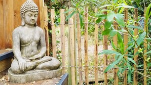A stone Buddha statue in a garden setting. - Pretty wooden house 5 minutes from the ocean (Labenne)