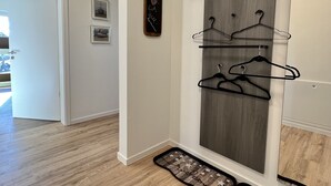 Ein Flur mit einer Holzwand, einem Kleiderständer und einer sternförmigen Ablage auf dem Boden.