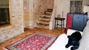 Ein Zimmer mit Stehwänden, einem roten Teppich mit Muster, einem weißen Sofa und einem schwarzen Stofftier.