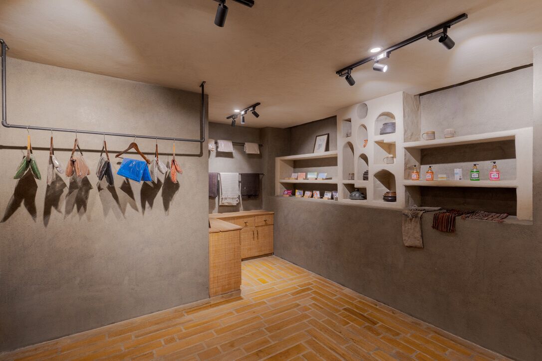 Una habitación con suelo de ladrillo, armarios de madera y estantes con artículos de tocador.