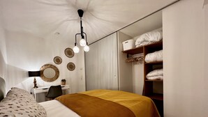 A bedroom with a bed, a desk, a chair, a wardrobe, and a mirror. - Modern apartment with charm (Kehl)