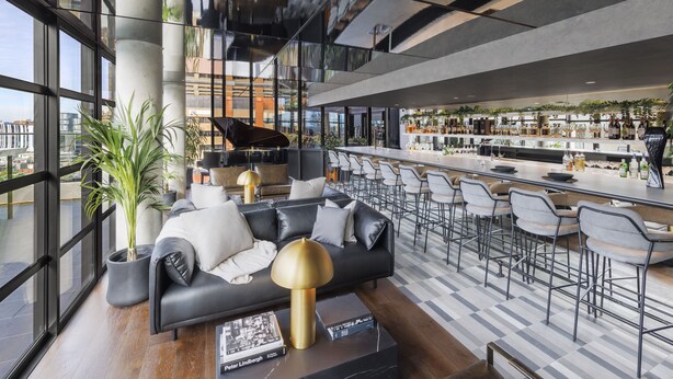Een moderne bar met een bank, stoelen en een bargedeelte.