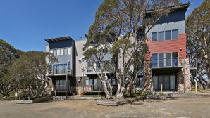 Un moderno conjunto de apartamentos con varios edificios, cada uno con fachadas de vidrio y metal.