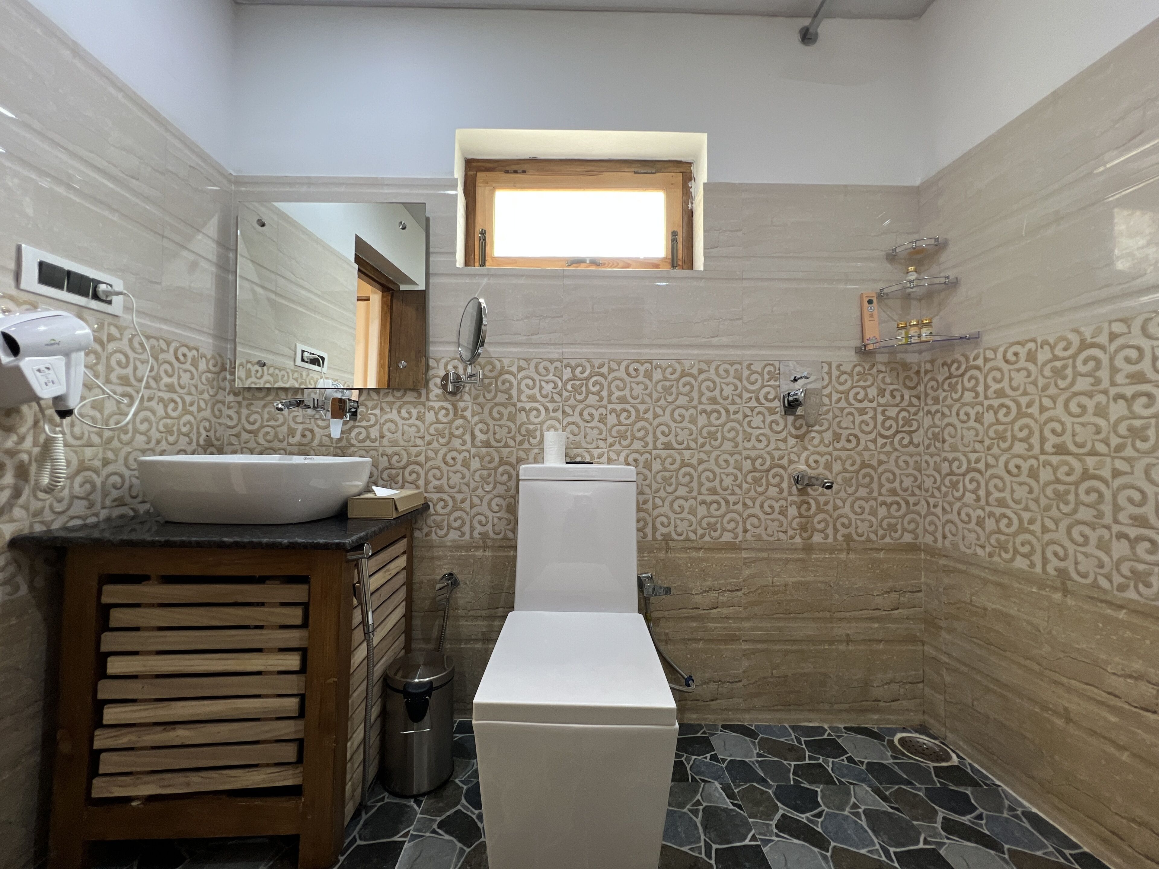 Ein Badezimmer mit Waschbecken, Toilette und einem Fenster.